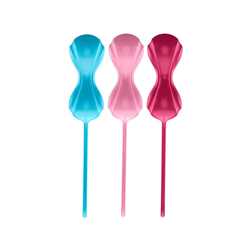 Three colorful plastic spoons in blue, pink, and red on a white background