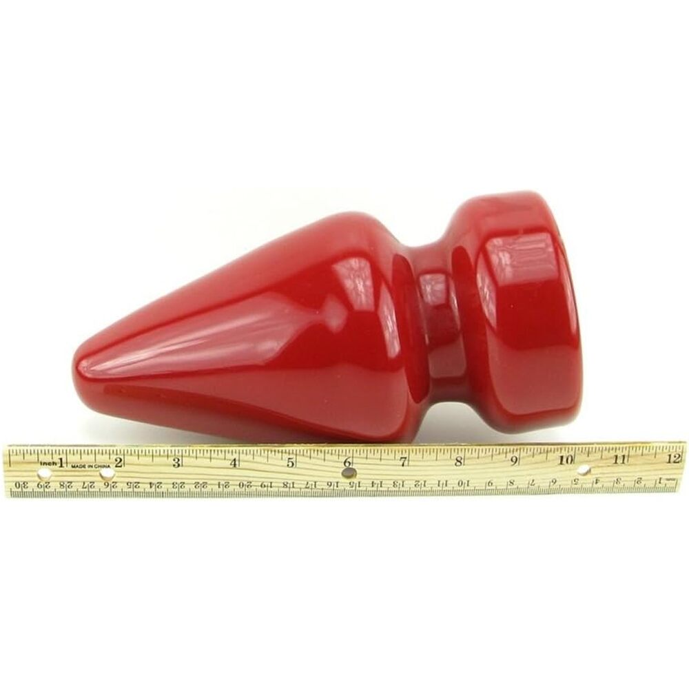 Red object with a measuring tape for scale on a white background