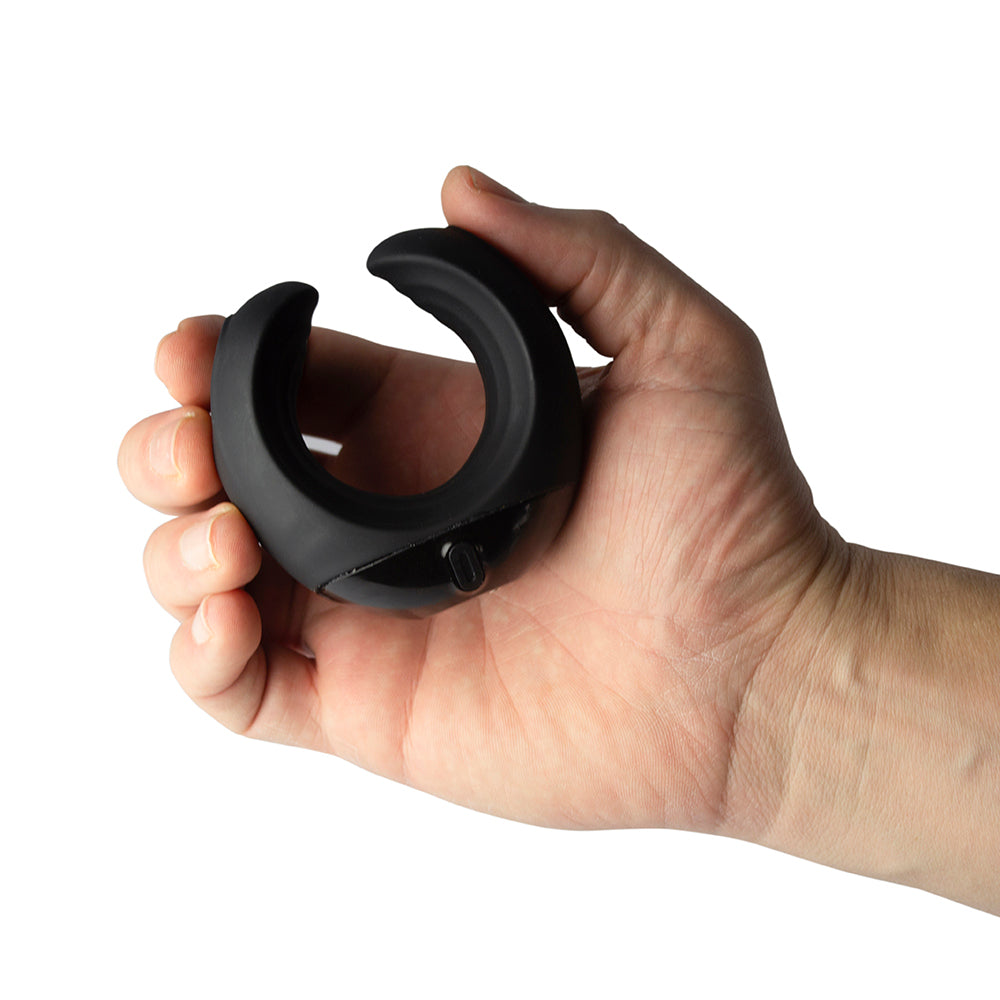 A hand holding a black, C-shaped silicone masturbator with a smooth exterior.
