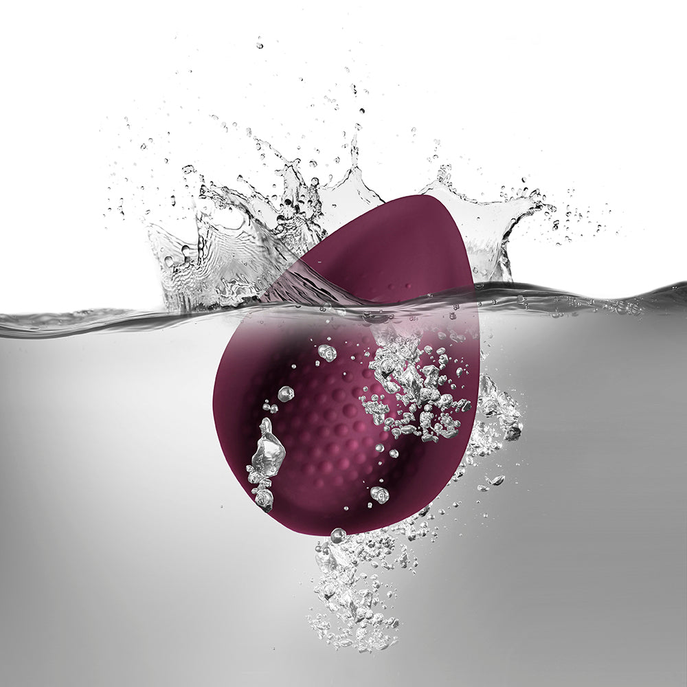 Purple object partially submerged in water with bubbles and splashes.