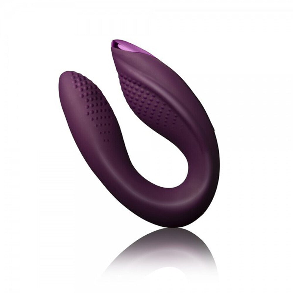 A purple, ergonomically shaped silicone vibrator with a smooth surface and textured details, designed for both clitoral and G-spot stimulation.