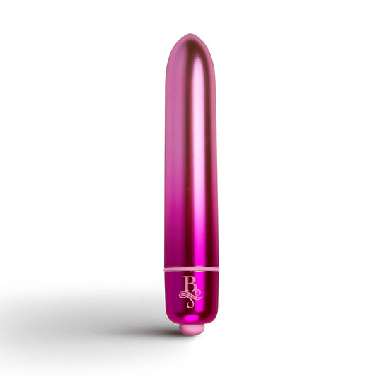 A pink, bullet-shaped vibrator placed on an open journal with a decorative heart-shaped lock and keys, surrounded by pink and white flowers.