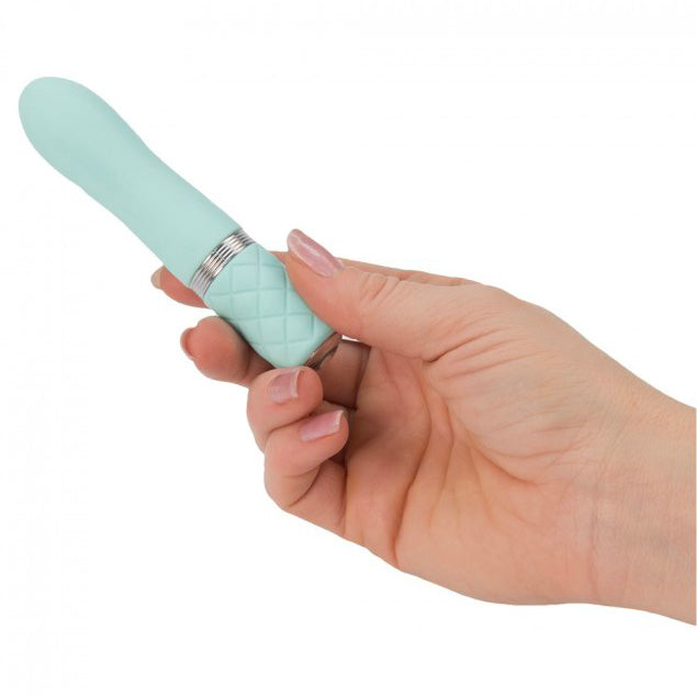 A small, teal-colored rechargeable bullet vibrator with a quilted handle and a metallic band near the base. It has a smooth, rounded tip and a Swarovski crystal button detail.
