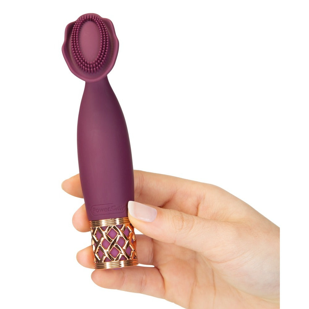 A handheld mini massager with a flexible, petal-shaped head and a gold-accented base, finished in purple.