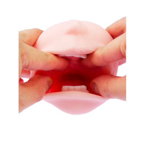 Pink silicone breast model held between hands on a white background