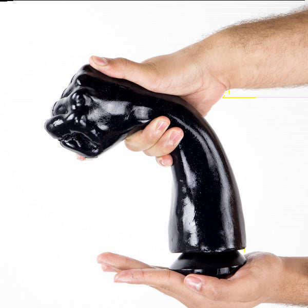 Black dog-shaped object held between two hands against a white background