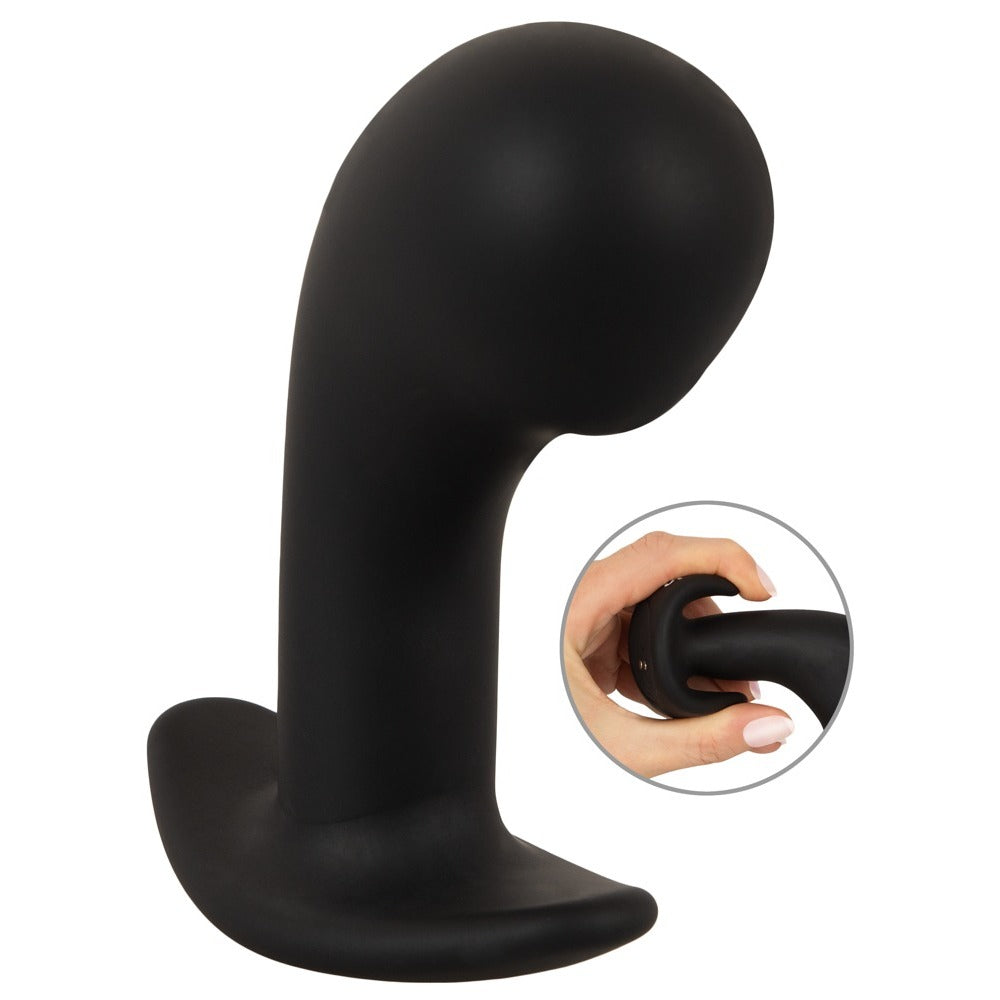 Black silicone butt plug with a hand holding it on a white background