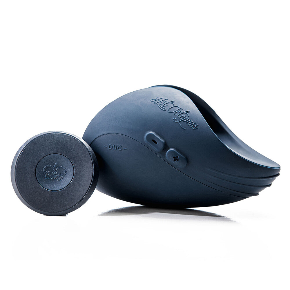 A blue Pulse Duo Guybrator Masturbator with Pulse Plate Technology, alongside its remote control. The toy has a sleek, ergonomic design with a circular base and a more angular, cushioned section.