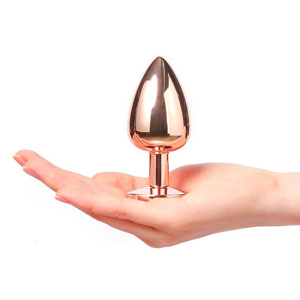Rose gold egg-shaped object held in a hand against a white background