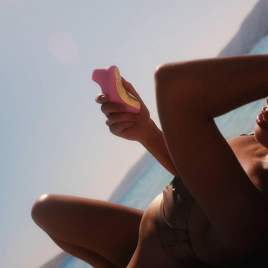 Person holding a pink object against a light blue sky