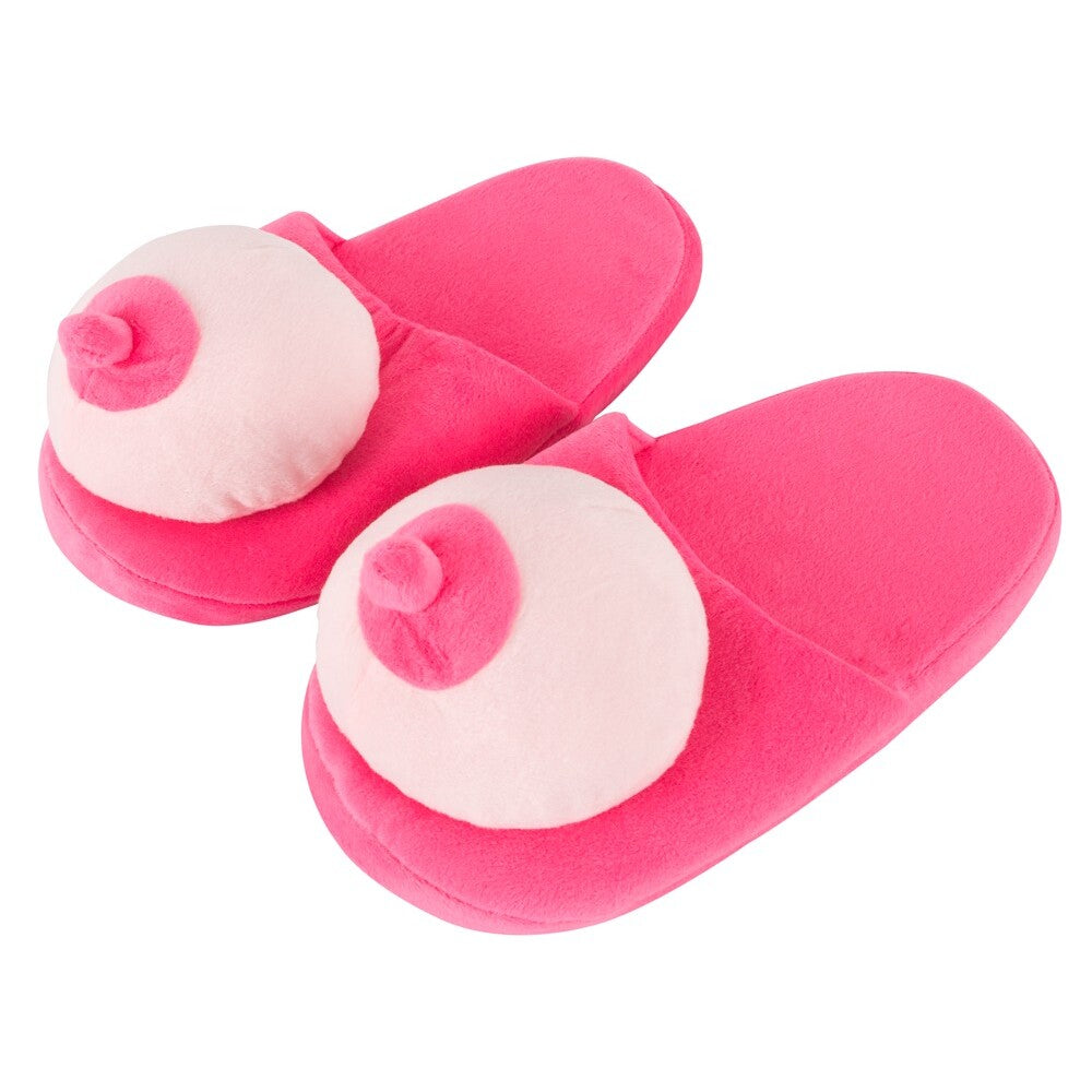 A pair of pink slippers made of fur fabric designed with boob-shaped tops.