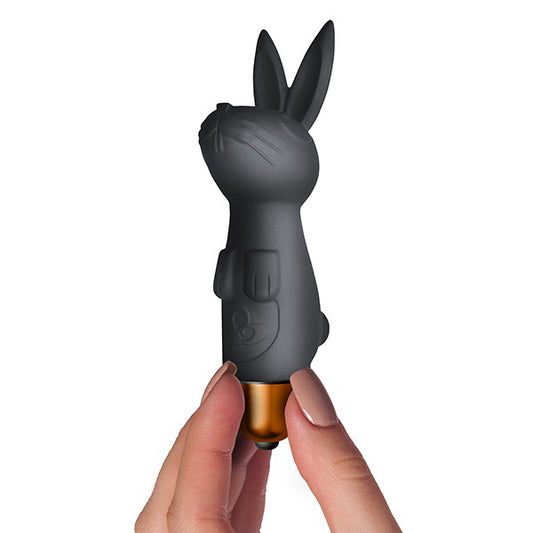 The image shows three black sexual wellness products. From left to right, there is a small cylindrical vibrator, a silicone bunny-shaped vibrator, and a larger, sleeker vibrator.