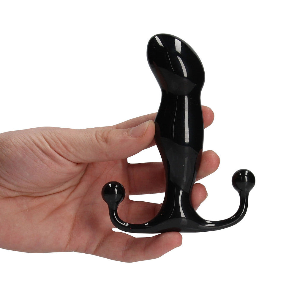 Black three-pronged object held in a hand against a white background
