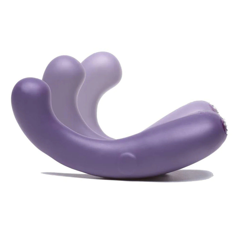 A purple, curved silicone stimulator with a smooth surface, featuring a button on its base for power control.