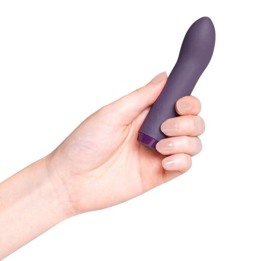 A purple bullet vibrator displayed in its open box, with the brand name Je Joue visible. The packaging includes a product card and a USB recharge cable.
