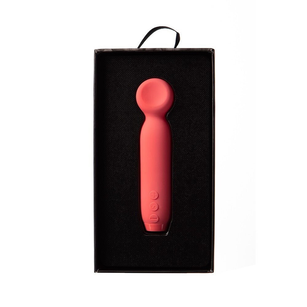A hand holding a red, bullet-shaped vibrator with a smooth, rounded tip.