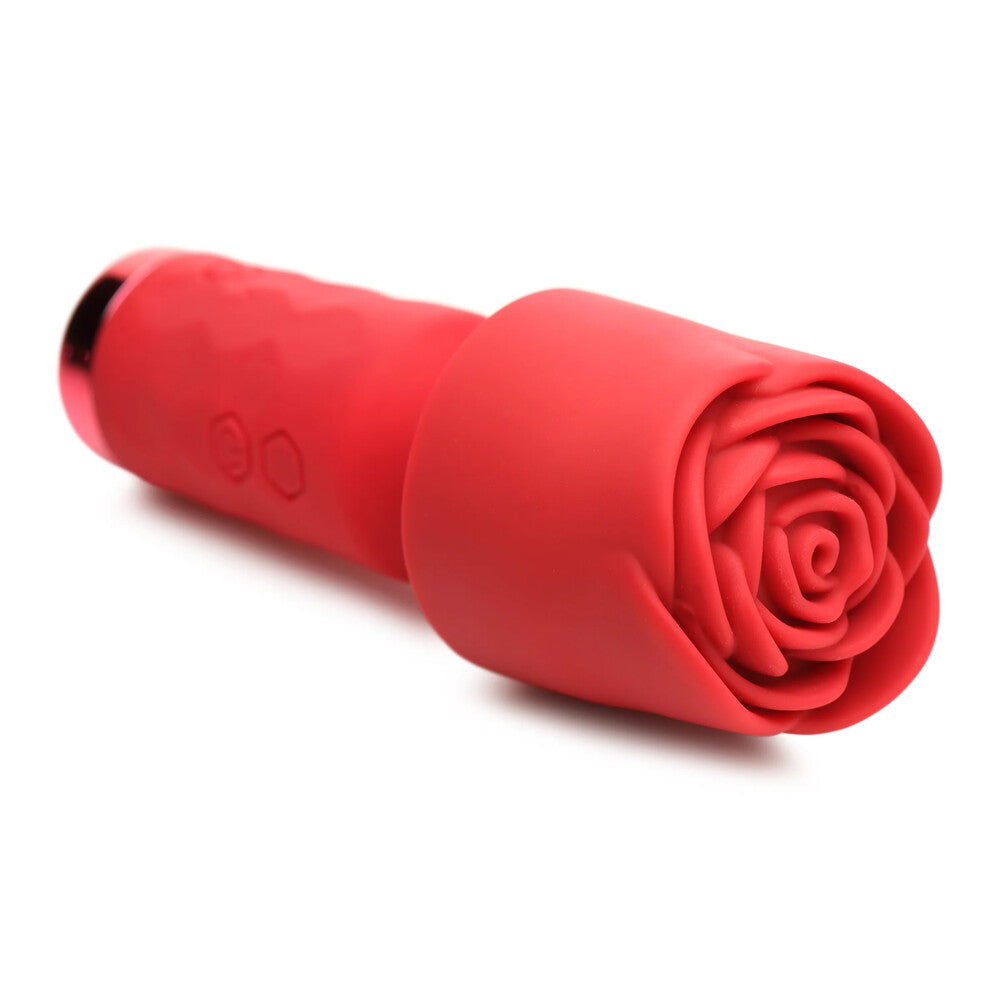 A hand holding a small, red, rose-shaped wand vibrator with a detachable sleeve.