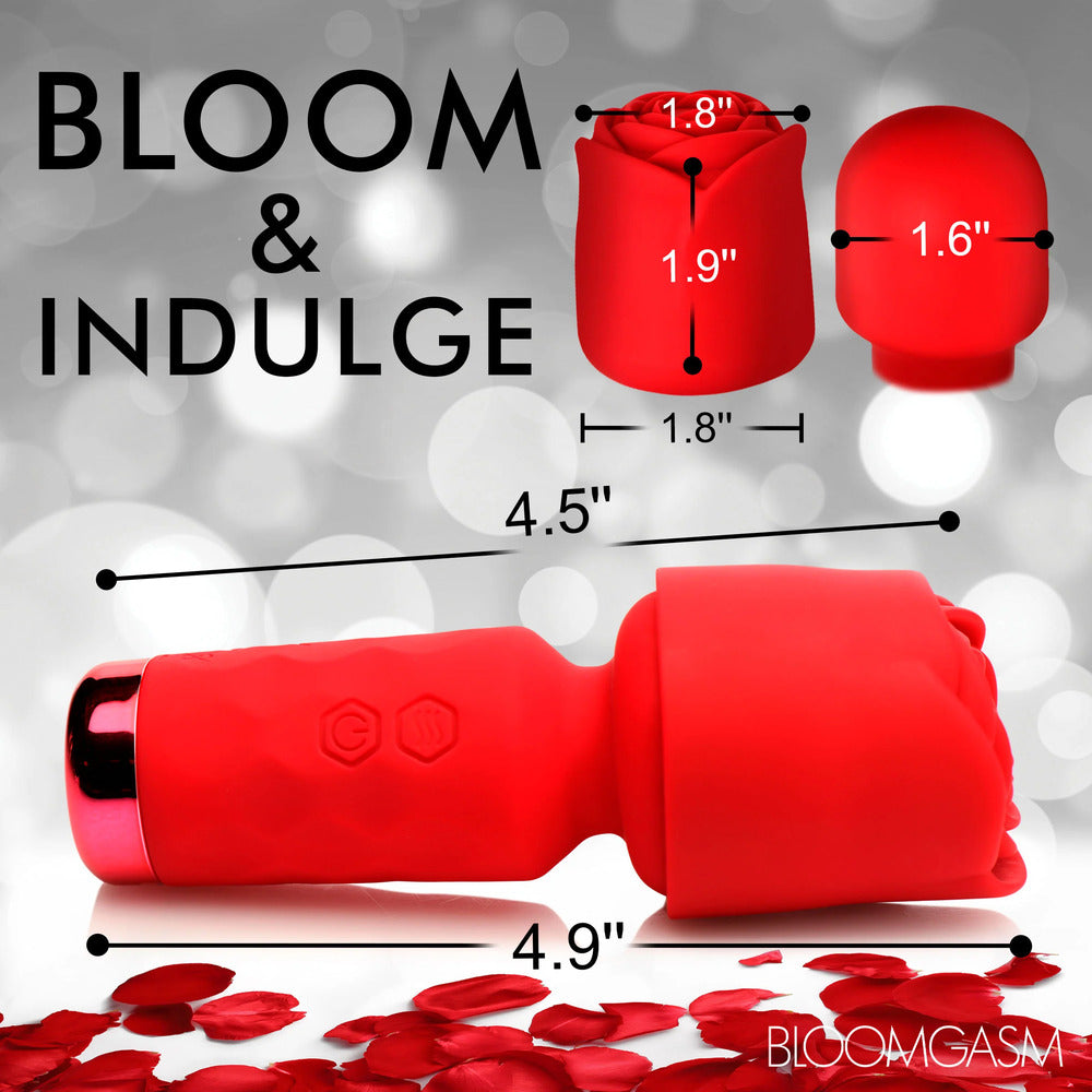 A hand holding a small, red, rose-shaped wand vibrator with a detachable sleeve.