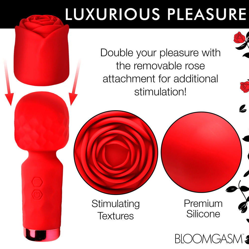 A hand holding a small, red, rose-shaped wand vibrator with a detachable sleeve.