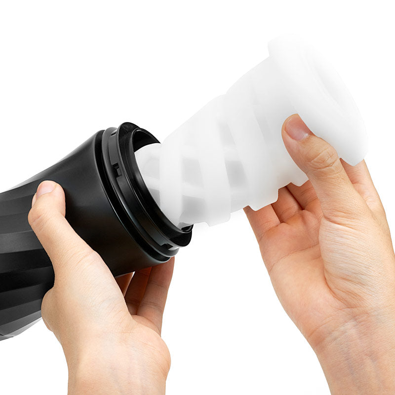 Person filling a black container with white powder on a plain background