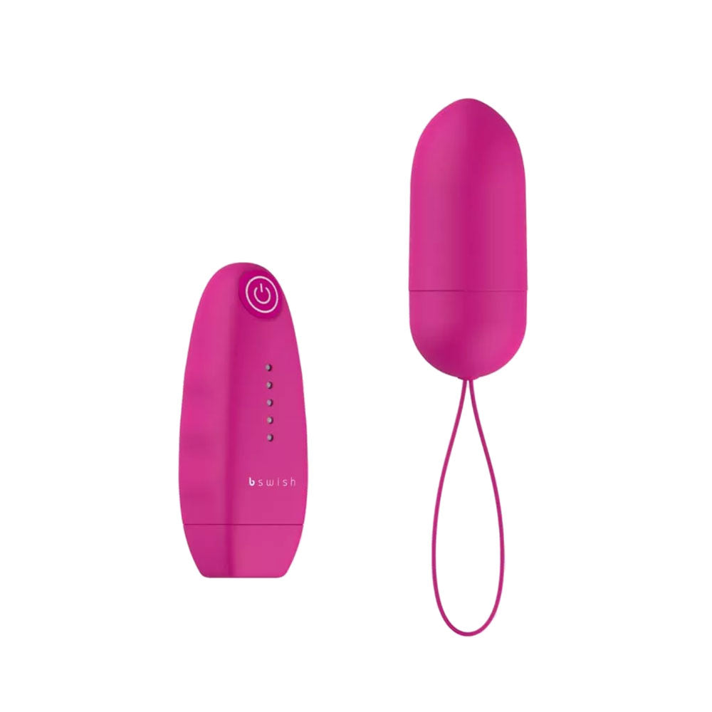 A pink, bullet-shaped massager with a wireless remote control featuring a single button for operation. The remote is also pink and has a white light indicator.