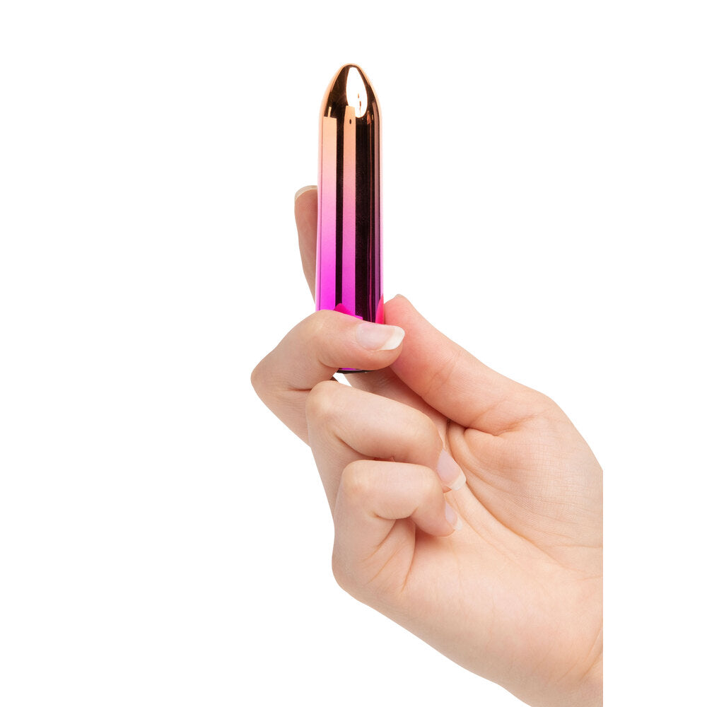 A hand holding a pink aluminium bullet vibrator with a sleek design.
