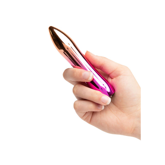 A hand holding a pink and metallic bullet vibrator.