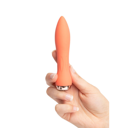 An orange, bullet-shaped vibrator being held in a hand, showing its sleek design and small size.