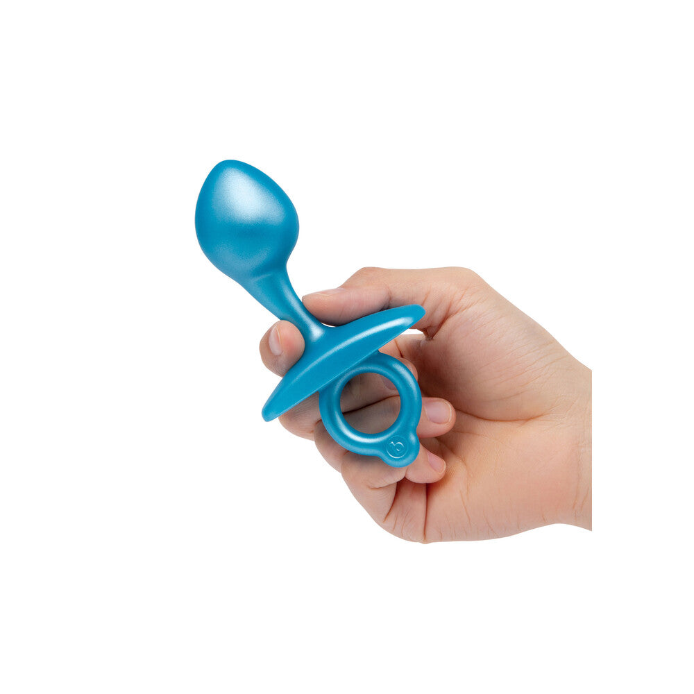 Hand holding a blue baby teether on a white background