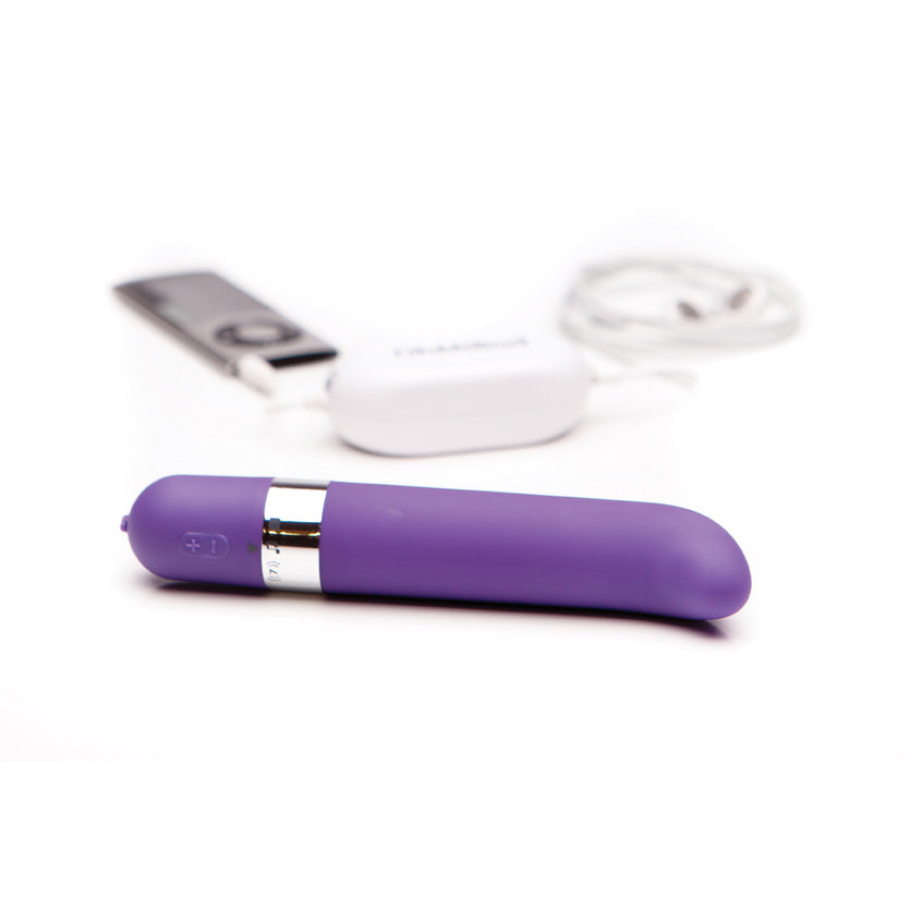 Purple cylindrical device with a white cup and tool in the background on a white background.