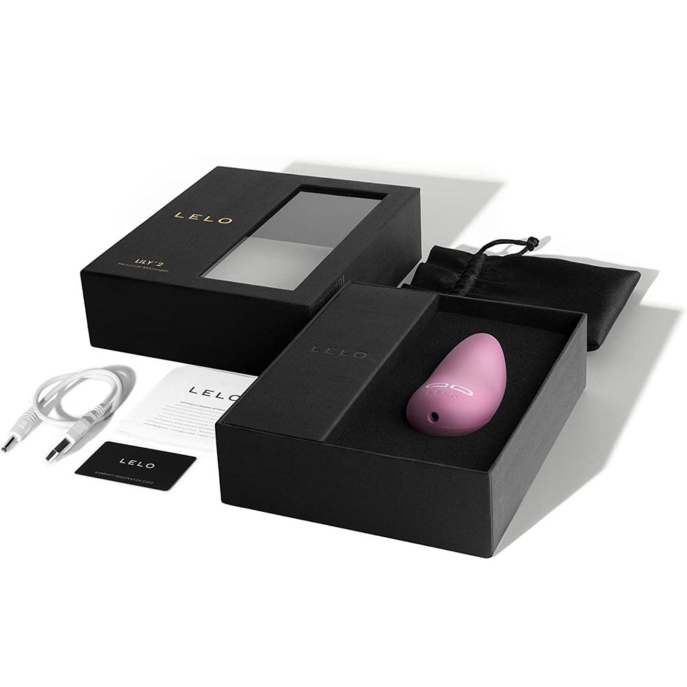 Pink electronic device in a black Lelo box with accessories on a white background