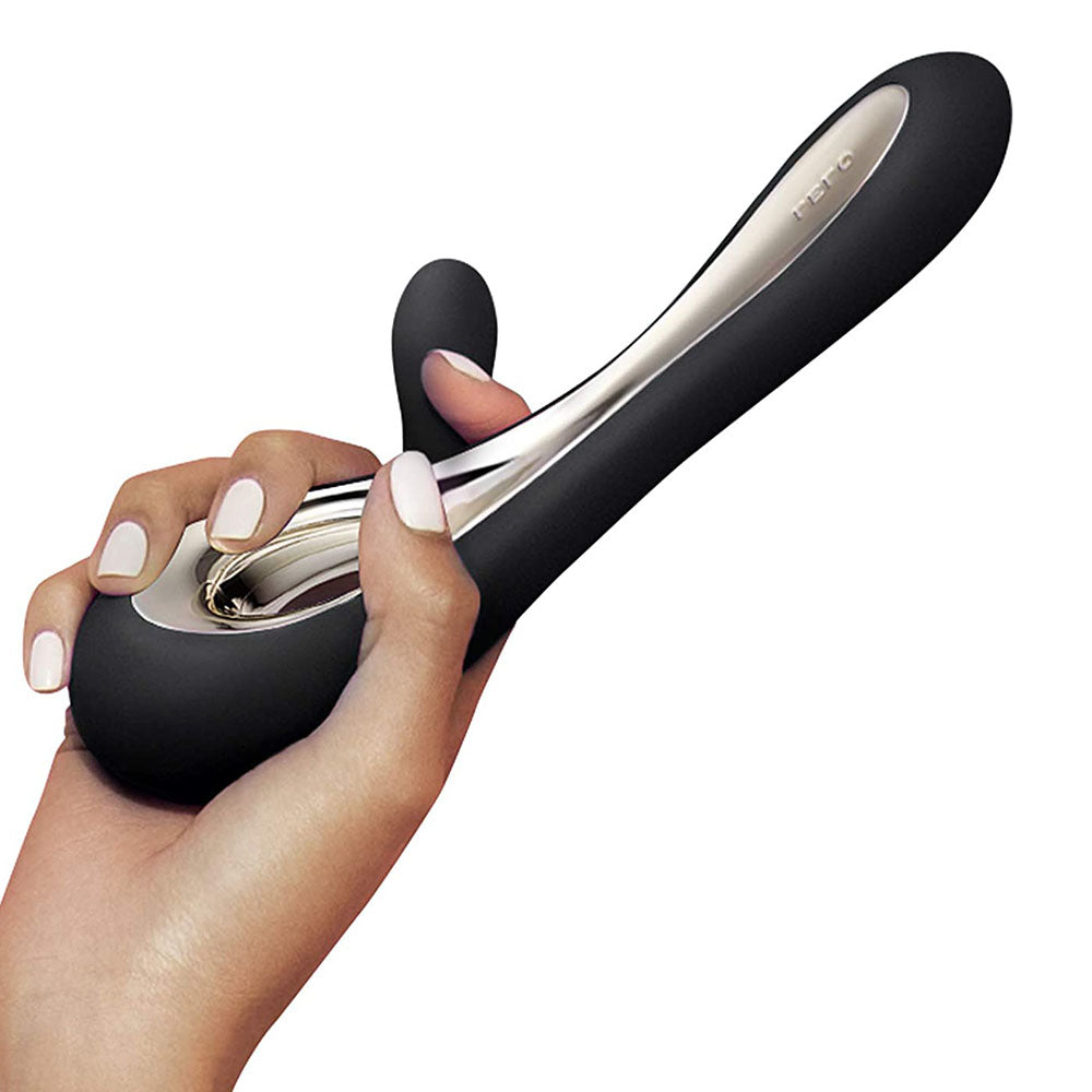 Hand holding a black and silver hair straightener against a white background