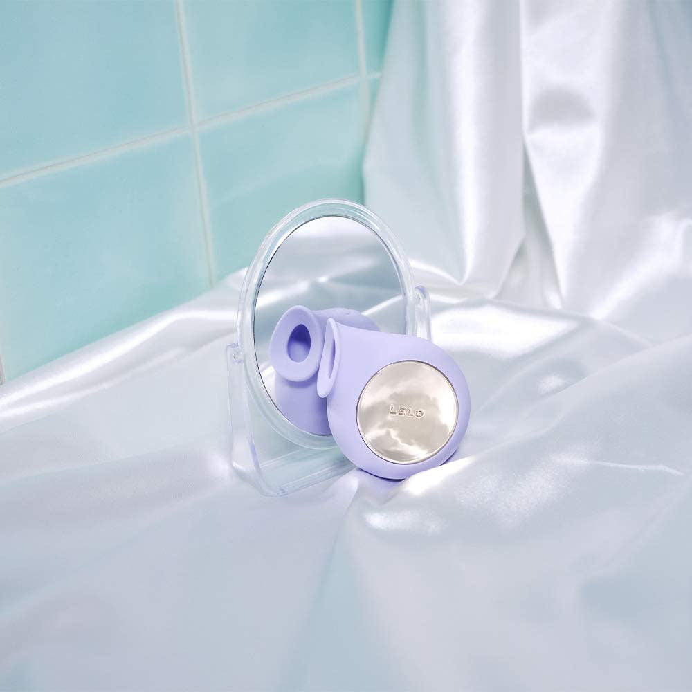 Purple and white cleaning brush on a bathtub with light blue tiles in the background