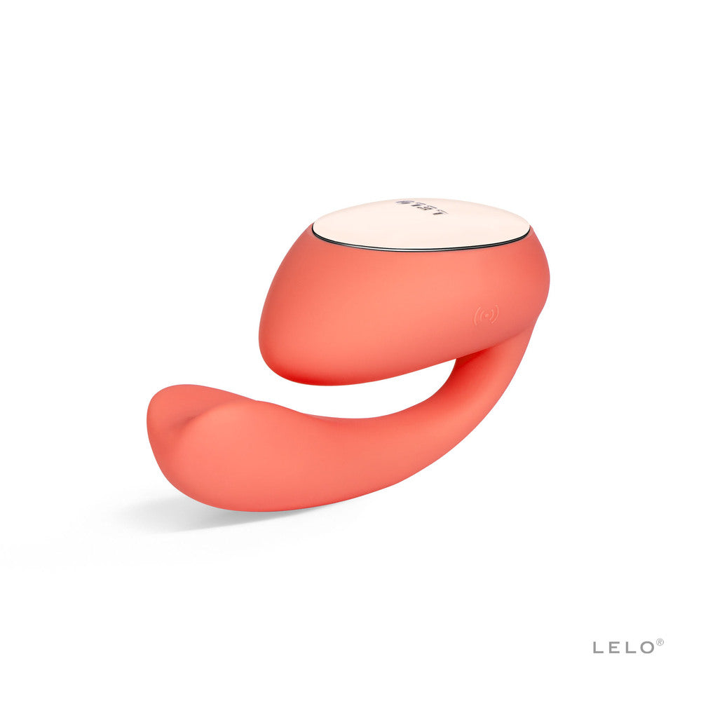 A coral-colored dual vibrator with a sleek, ergonomic design featuring a larger tip and a rotating, insertable tail.