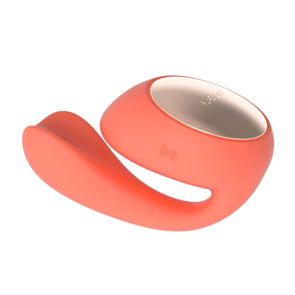 A coral-colored dual vibrator with a sleek, ergonomic design featuring a larger tip and a rotating, insertable tail.