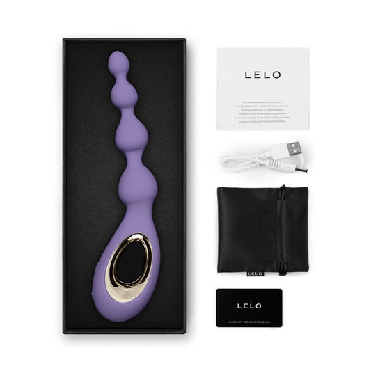 Purple and gold Lelo product with packaging, USB cable, and user manual on a white background