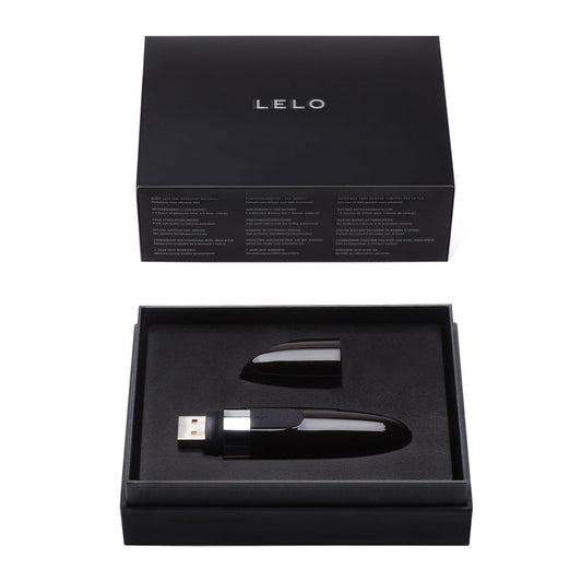 A sleek, black lipstick-style vibrator with a smooth surface, USB charging port, and ergonomic design.