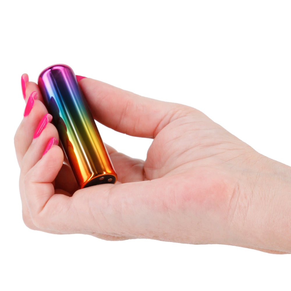 The image shows a slim and colorful vibrator with a gradient of rainbow colors, reflecting a shiny, metallic finish.