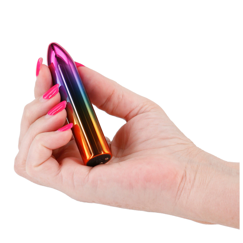 The product image shows a slim, multicolored vibrator in a box with a clear display of its rainbow colors. The box is labeled with the brand name 'Chroma' and the product name 'Rainbow Rechargeable Bullet'.