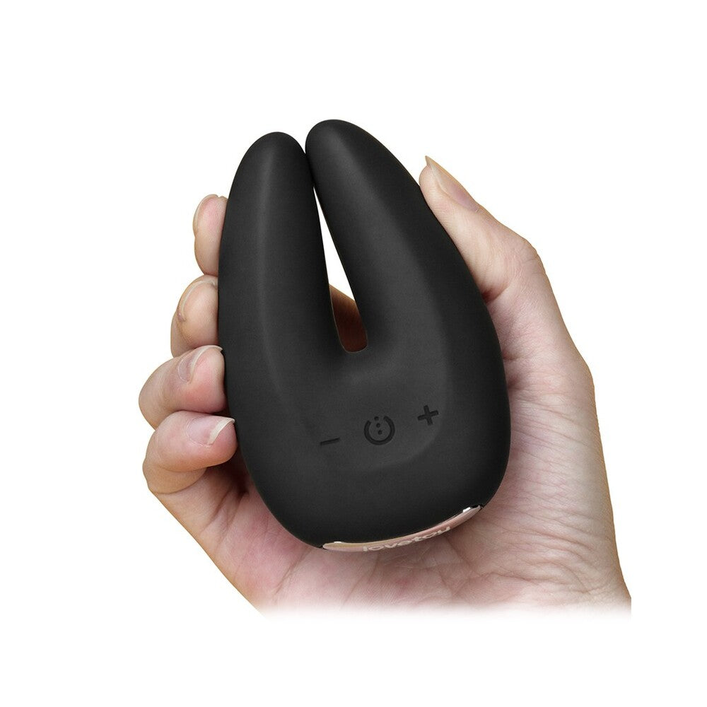 Black handheld device with a cute face design held in a hand on a white background
