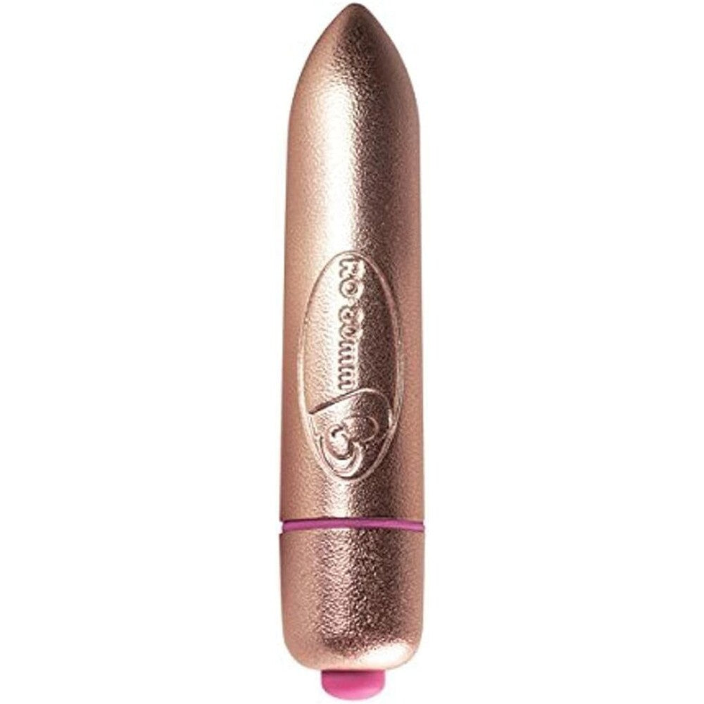 A small, gold-colored bullet vibrator being held between fingers, showing its compact size and sleek design.