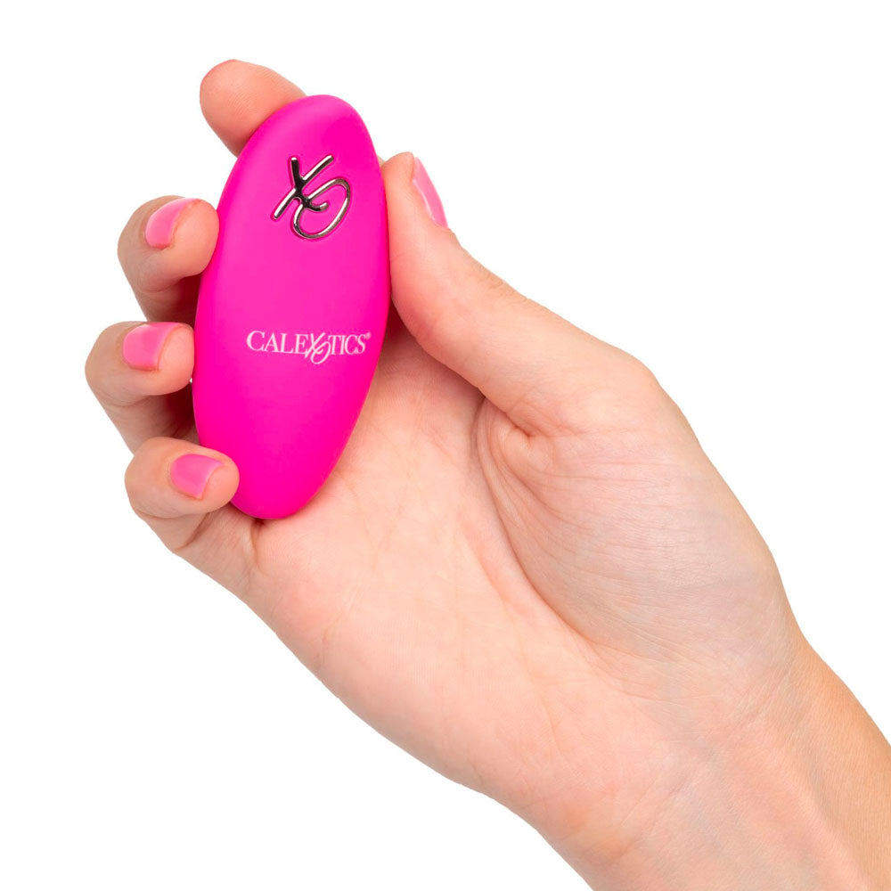 Hand holding a pink device with a logo on a white background