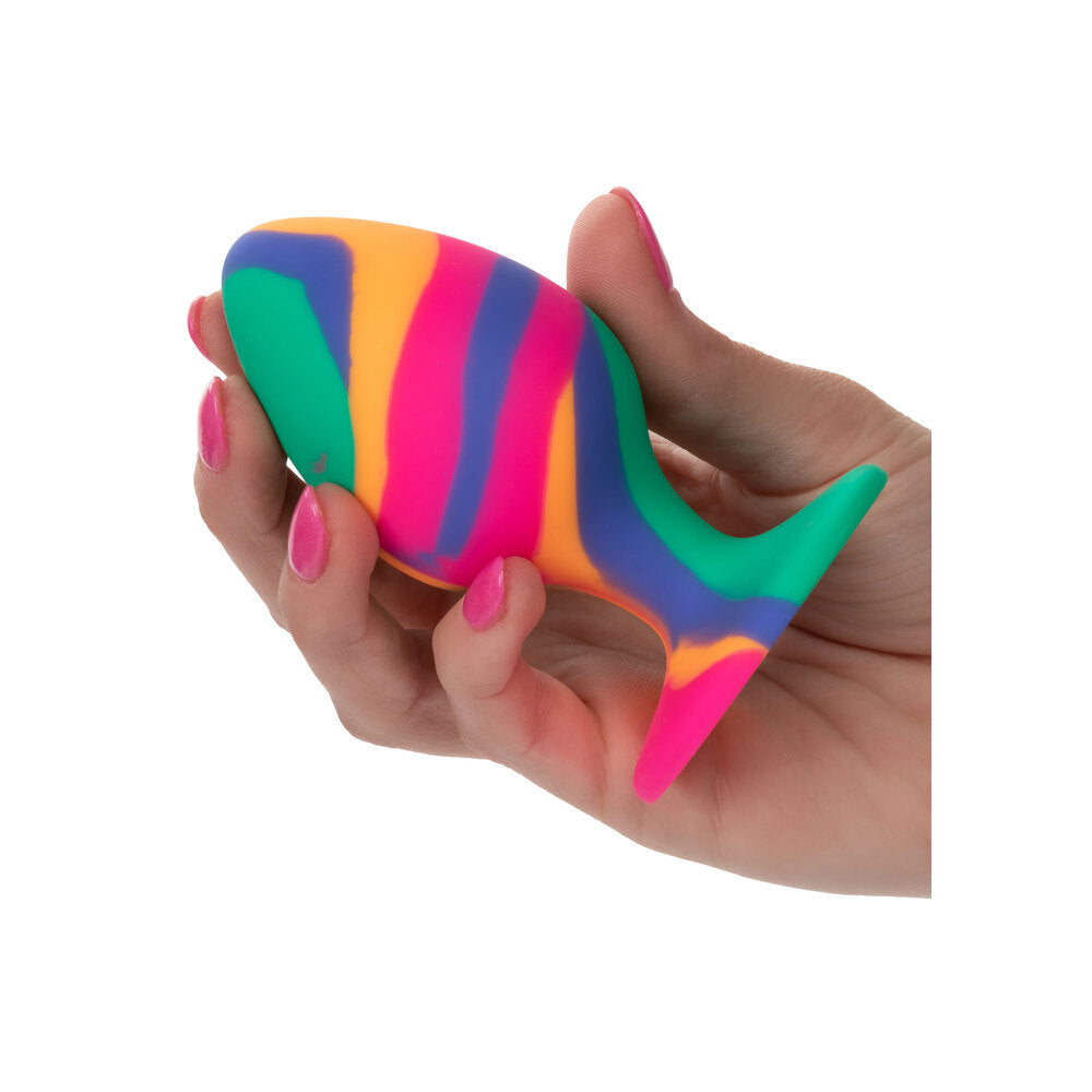 Hand holding a colorful fish-shaped stress reliever toy on a white background