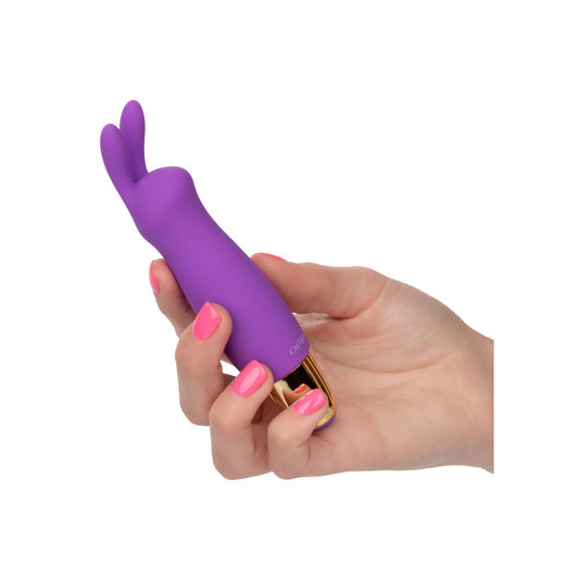 A purple mini rabbit clitoral massager with a silicone head and a gold base. The massager has two flickering ears and an easy-touch control button.