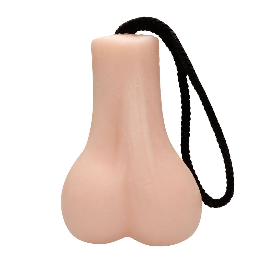 A pink bar of soap designed to resemble male genitalia, attached to a black rope for hanging. The soap is displayed against a white background.