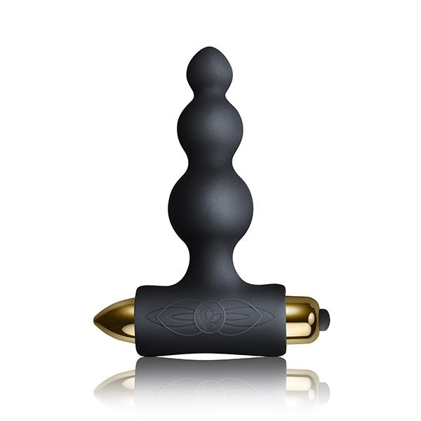 The image shows a black silicone T-shaped base and a golden bullet vibrator, indicating the kit includes these items for couple's pleasure.