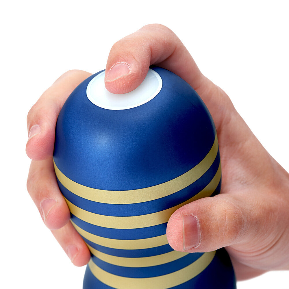Hand holding a blue and yellow striped stress ball against a white background