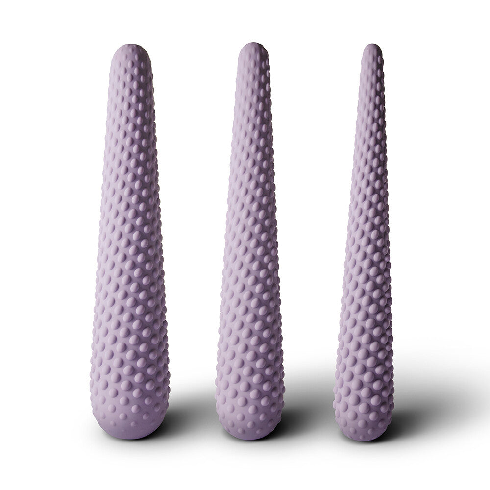 A set of three purple silicone dilators of varying sizes, each with a textured surface.