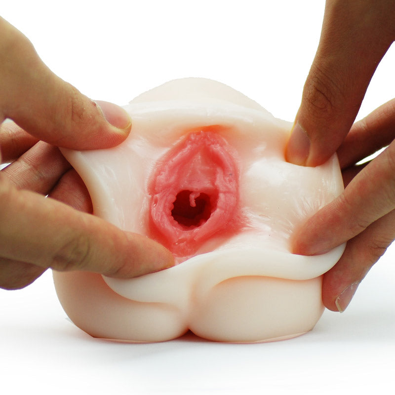 A flesh-pink colored masturbator with a complex textured interior designed to mimic the female genitalia, featuring an autograph on the exterior.