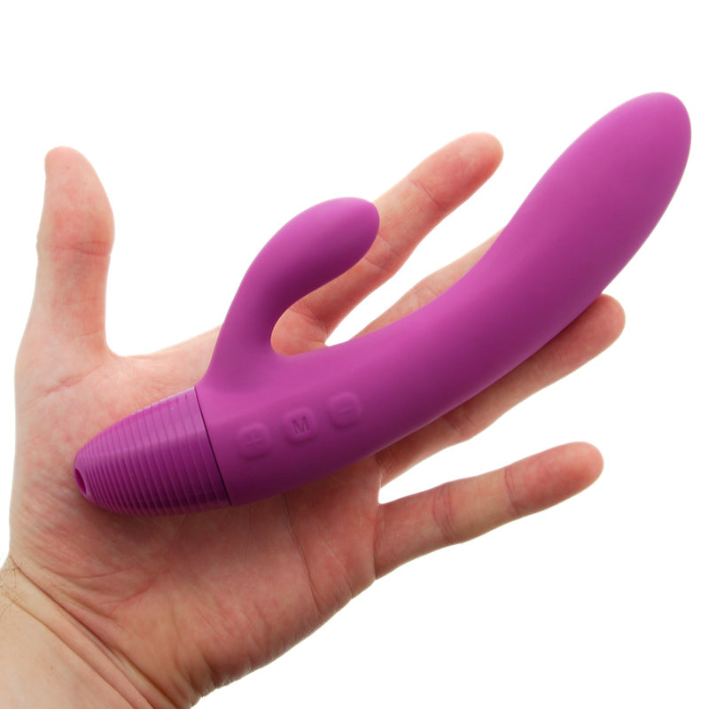 Purple silicone butt plug held in a hand on a white background